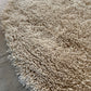 Edge detail of handwoven white shaggy wool rug showing thick plush pile height and natural wool construction