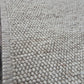 handwoven beige wool chunky loop rug beside bed bedroom interior neutral tones custom size Lav and Lira
