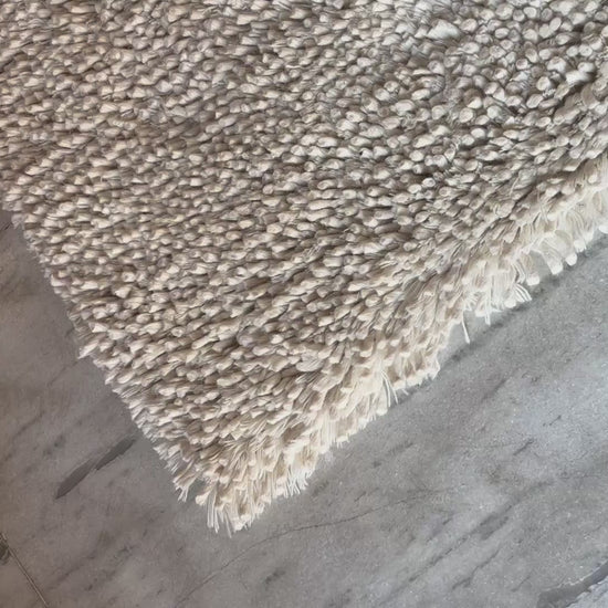 Video showing the plush texture and quality of handwoven white wool shaggy rug by LavnLira, custom made in Varanasi