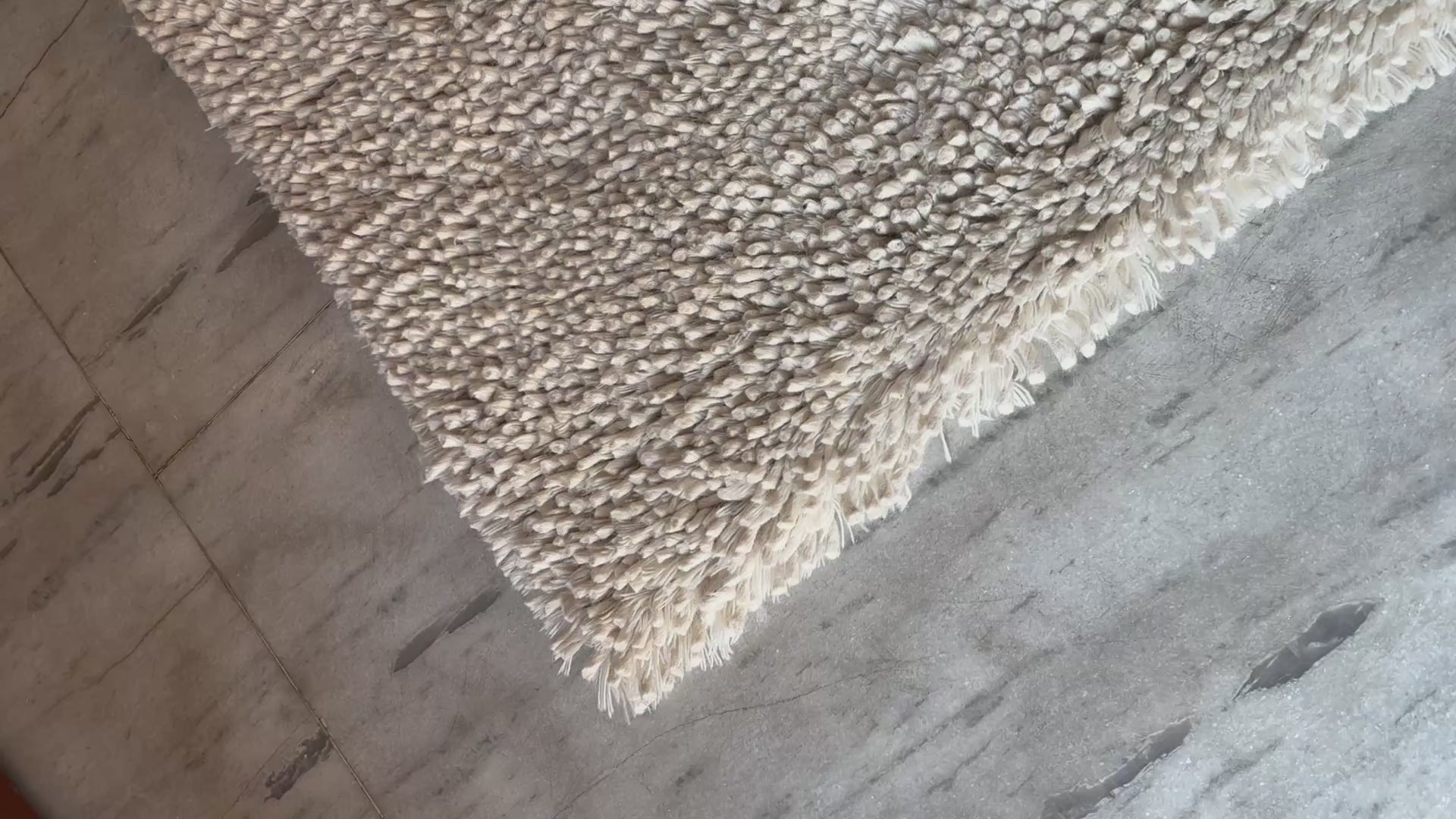 Video showing the plush texture and quality of handwoven white wool shaggy rug by LavnLira, custom made in Varanasi